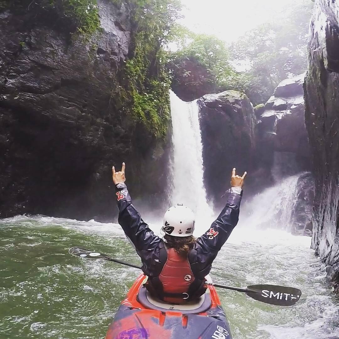 Diego celebrating at the base of a waterfall